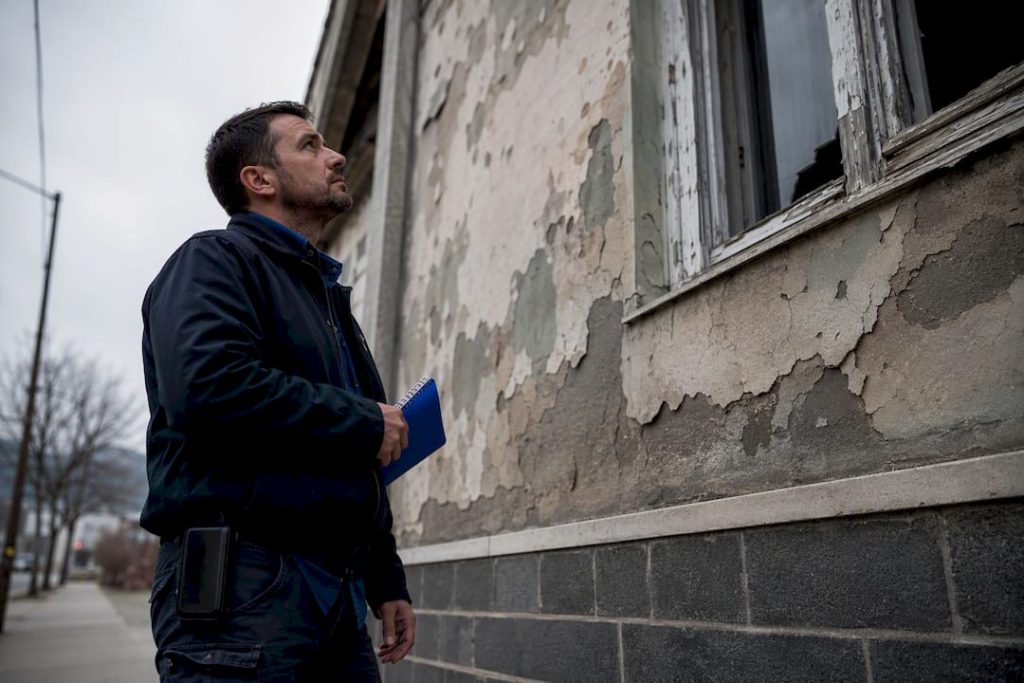 Inspector municipal inspeccionando la fachada de una vivienda